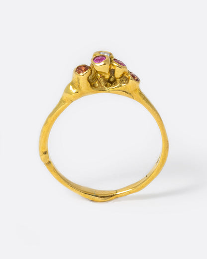 18k yellow gold teeny sea anemone ring with pink sapphires, orange sapphires, and diamonds by Kimberlin Brown, shown standing up from the side.