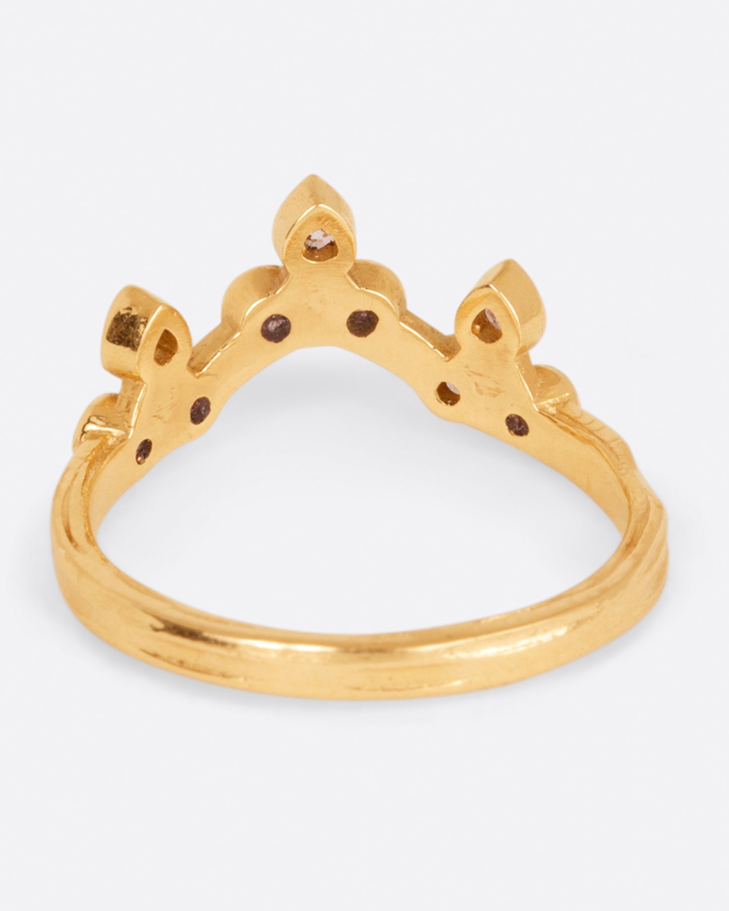 A curved yellow gold ring with a crown of round white diamonds, shown from the back.