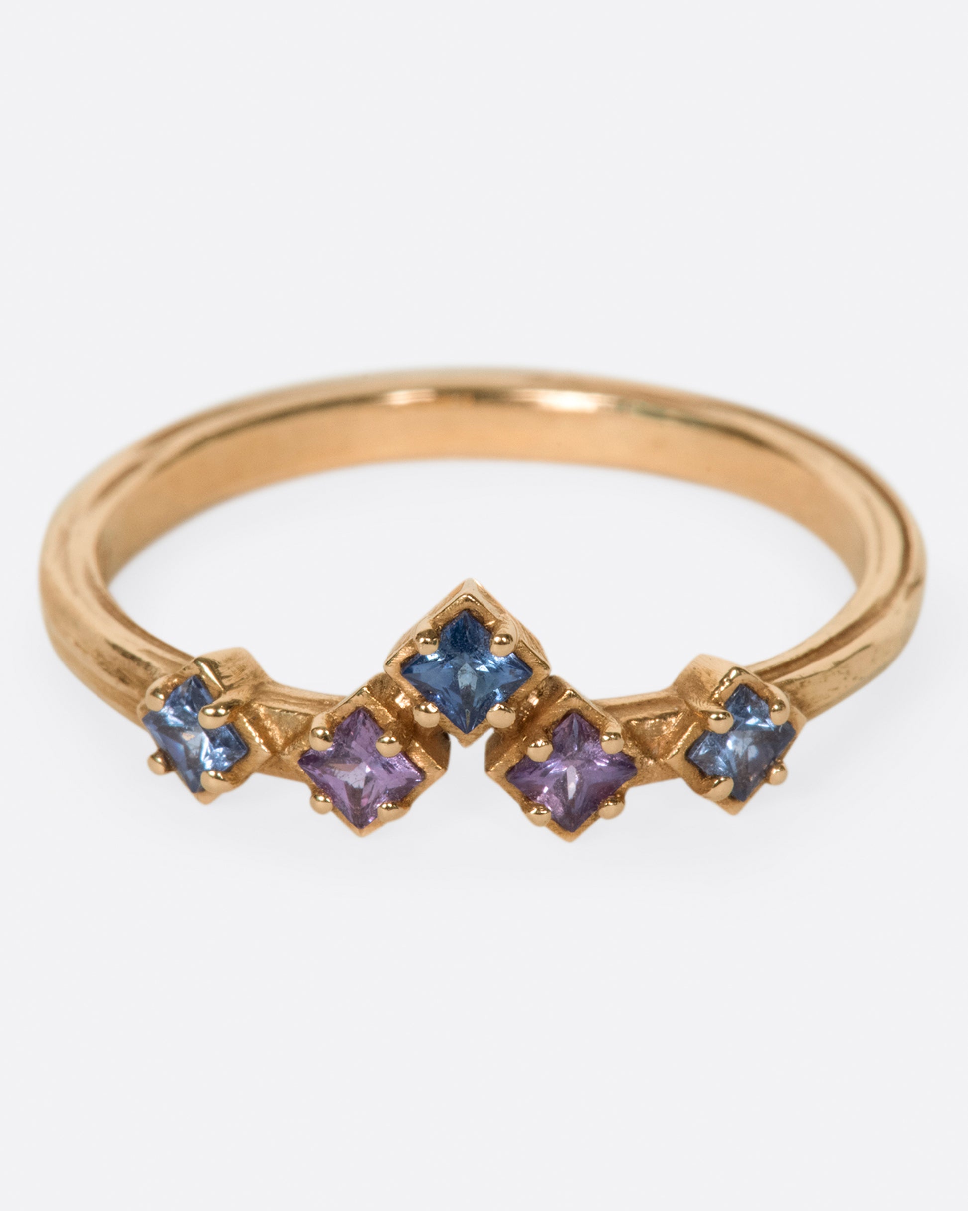 Inspired by the architecture of Tokyo, this curved band features princess cut blue and purple sapphires.