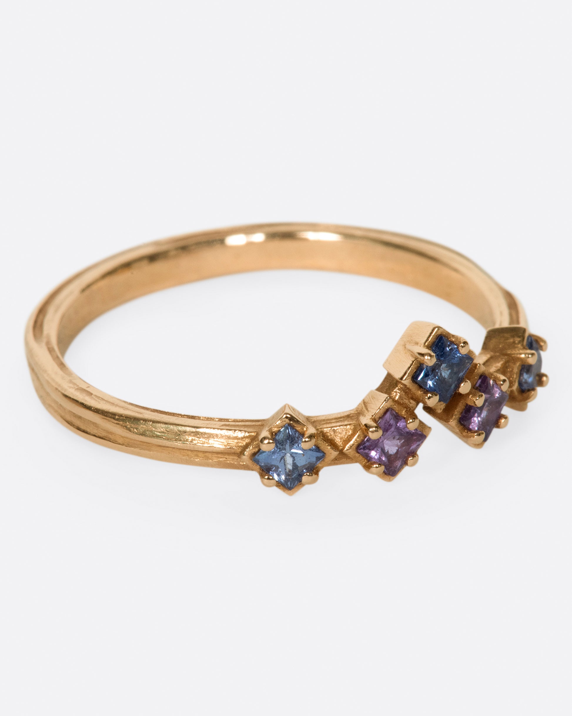 Inspired by the architecture of Tokyo, this curved band features princess cut blue and purple sapphires.