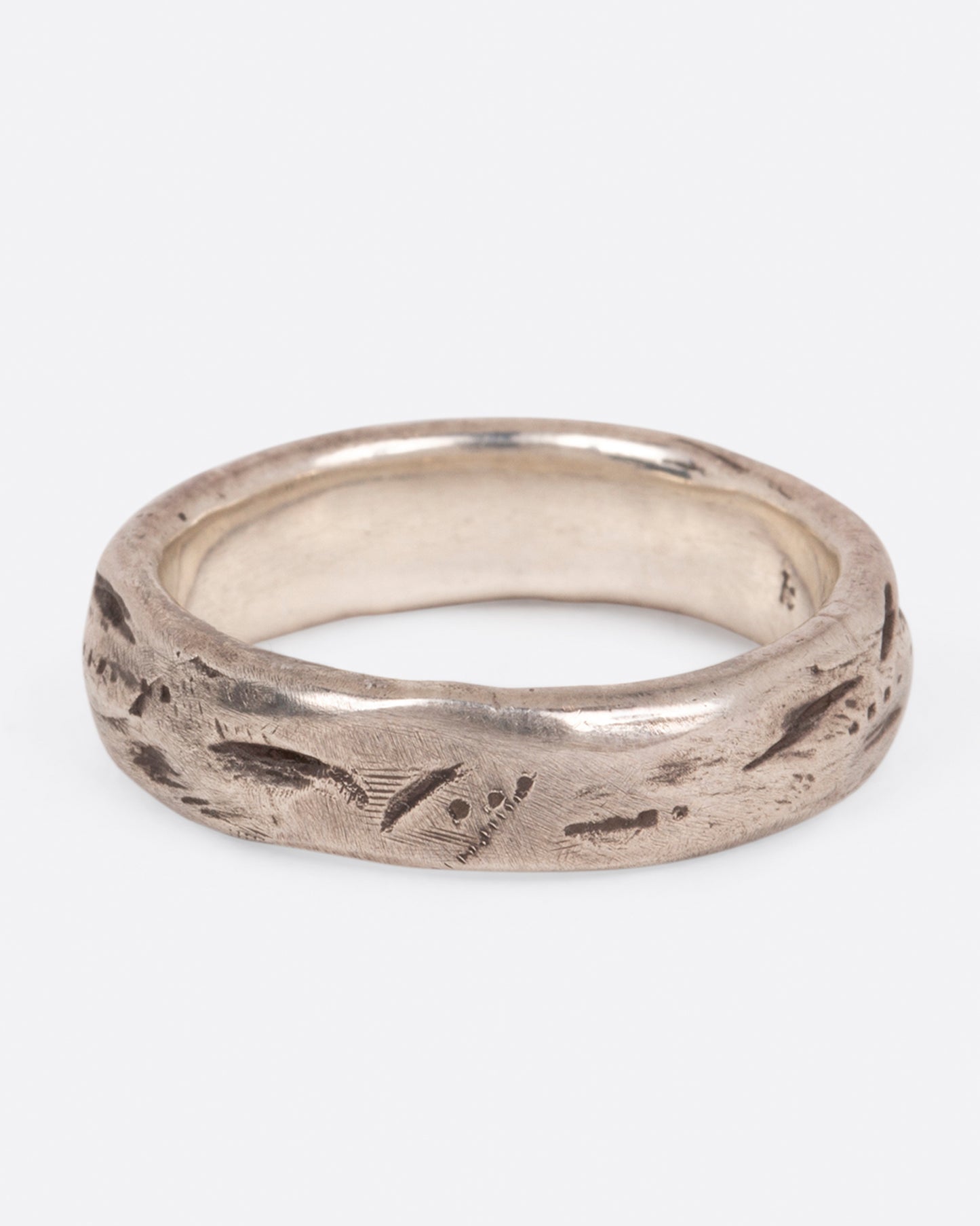 A textured sterling silver band that is meant to look worn in, shown from the front.