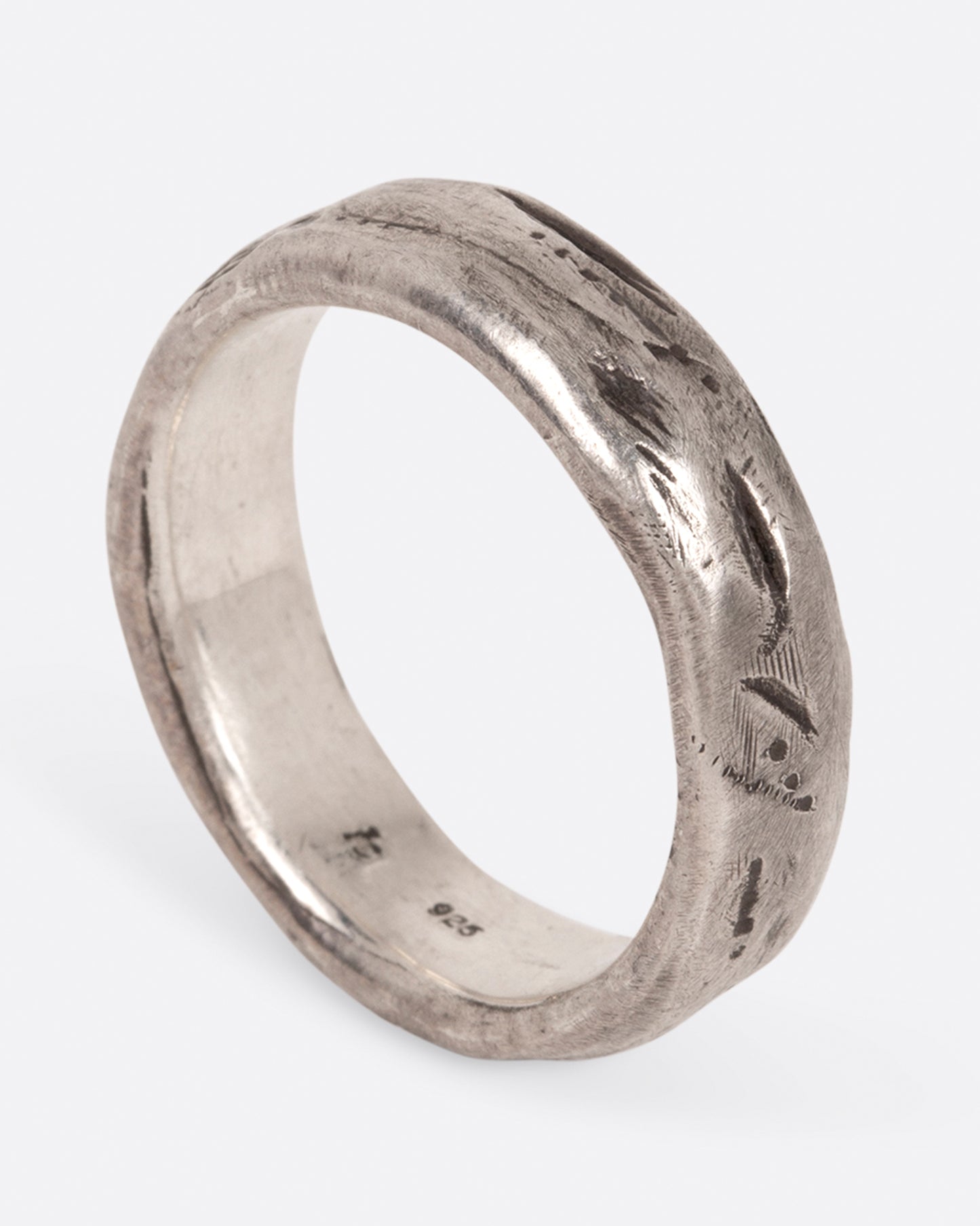 A textured sterling silver band that is meant to look worn in, shown standing up