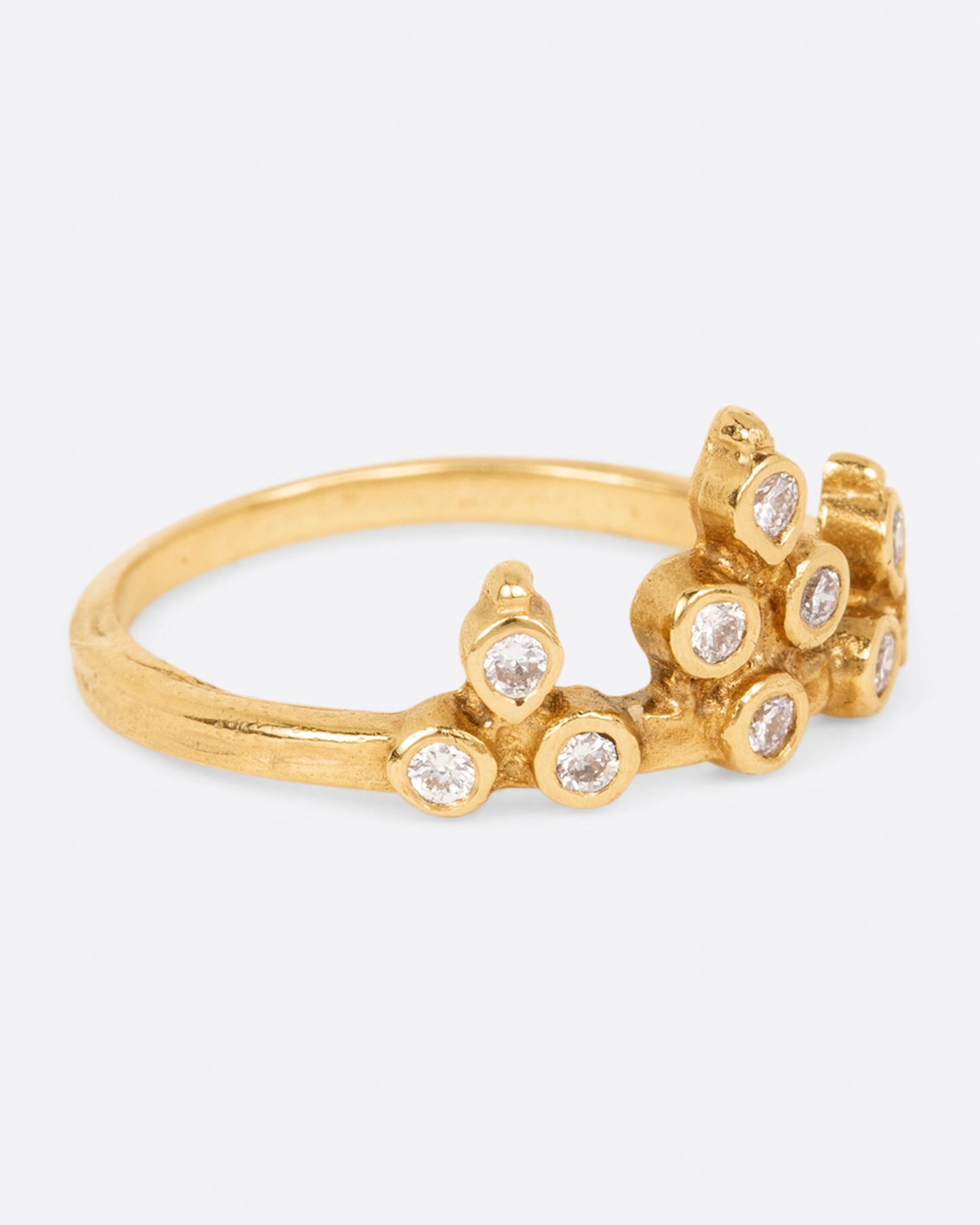 A yellow gold crown ring with round white diamonds, shown from the side.