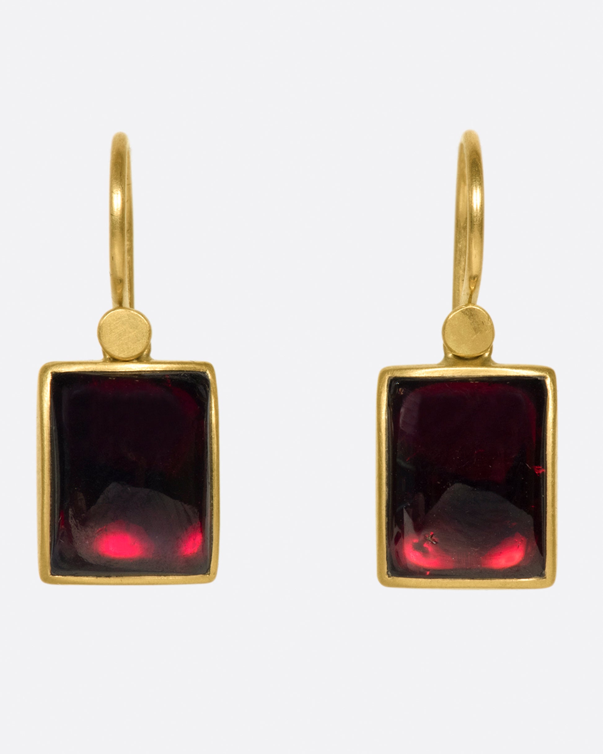 A pair of rectangular, dark red garnet cabochons set in Lola Brooks' signature bezel settings.