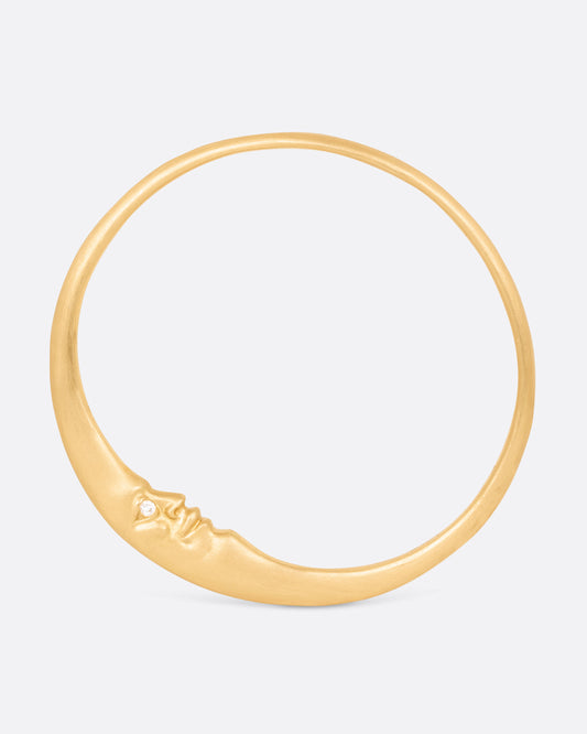 A yellow gold bangle bracelet with a moonface and diamond eyes, shown from the front.
