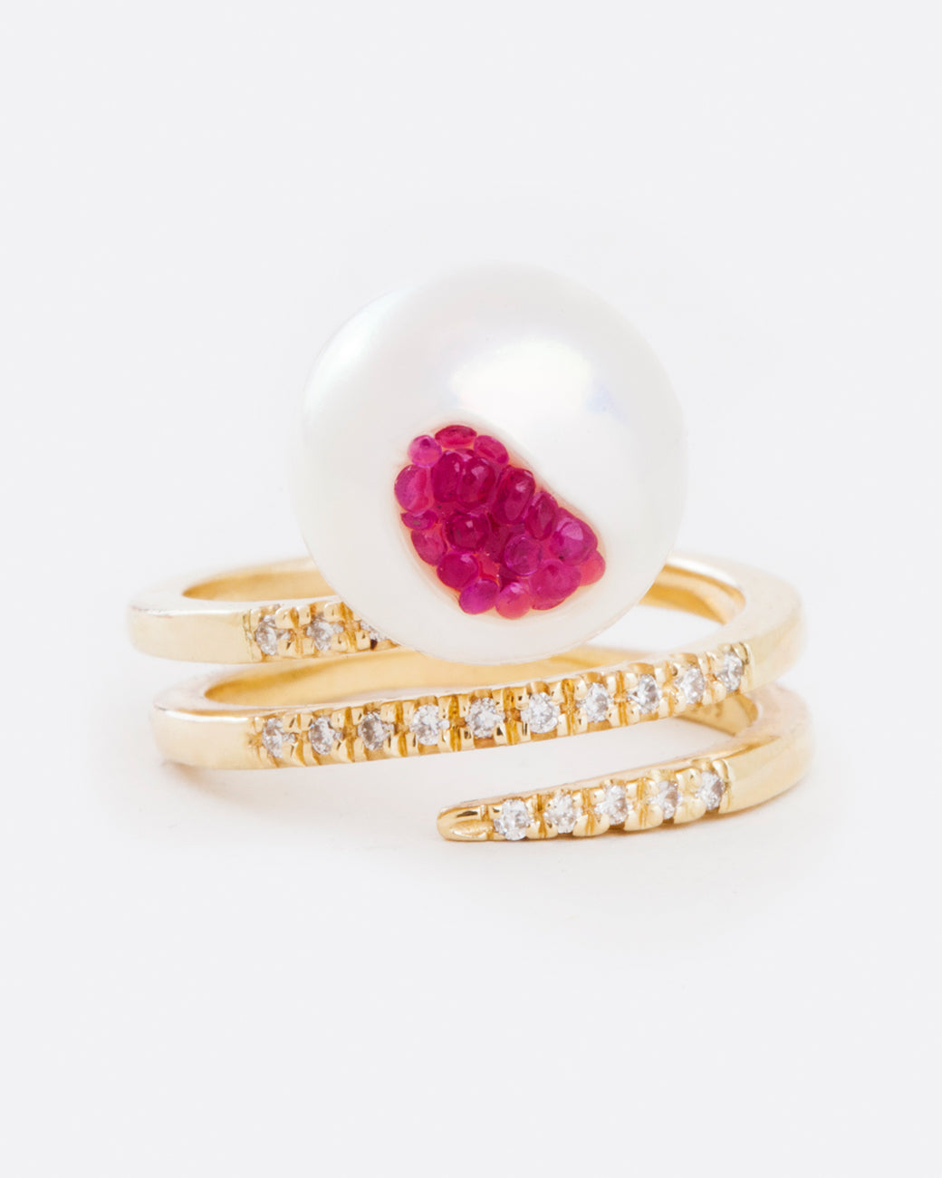 straight on view of a little h yellow gold wrap ring finished with an organic freshwater pearl that has been gutted and lined with rubies