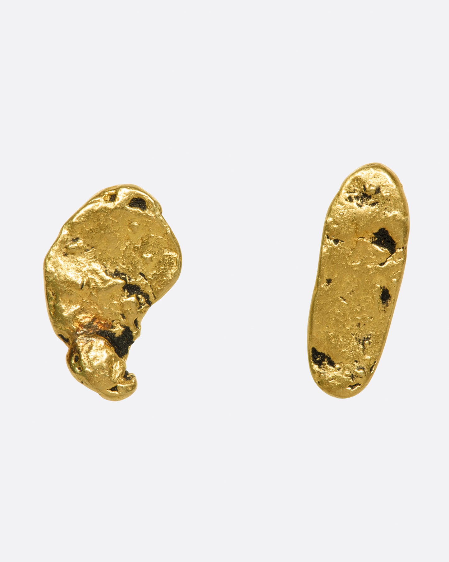 A pair of mismatched gold nugget stud earrings, shown from the front.