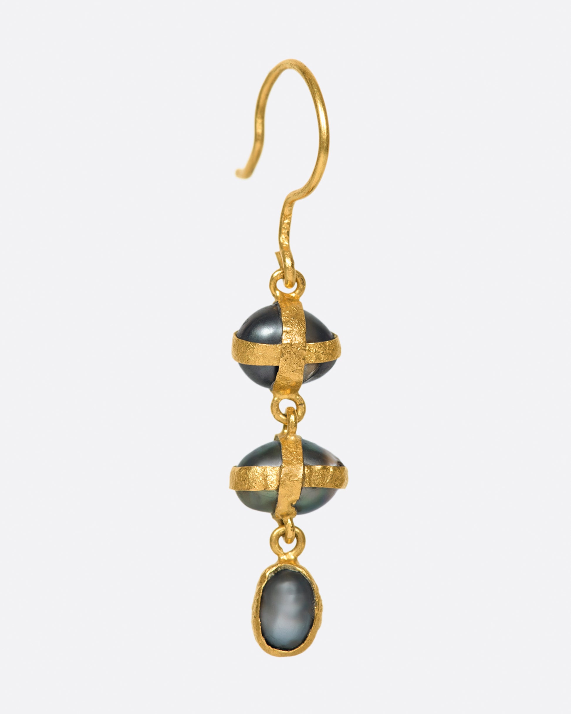 Three dark gray pearls wrapped in high karat gold on this single earring.