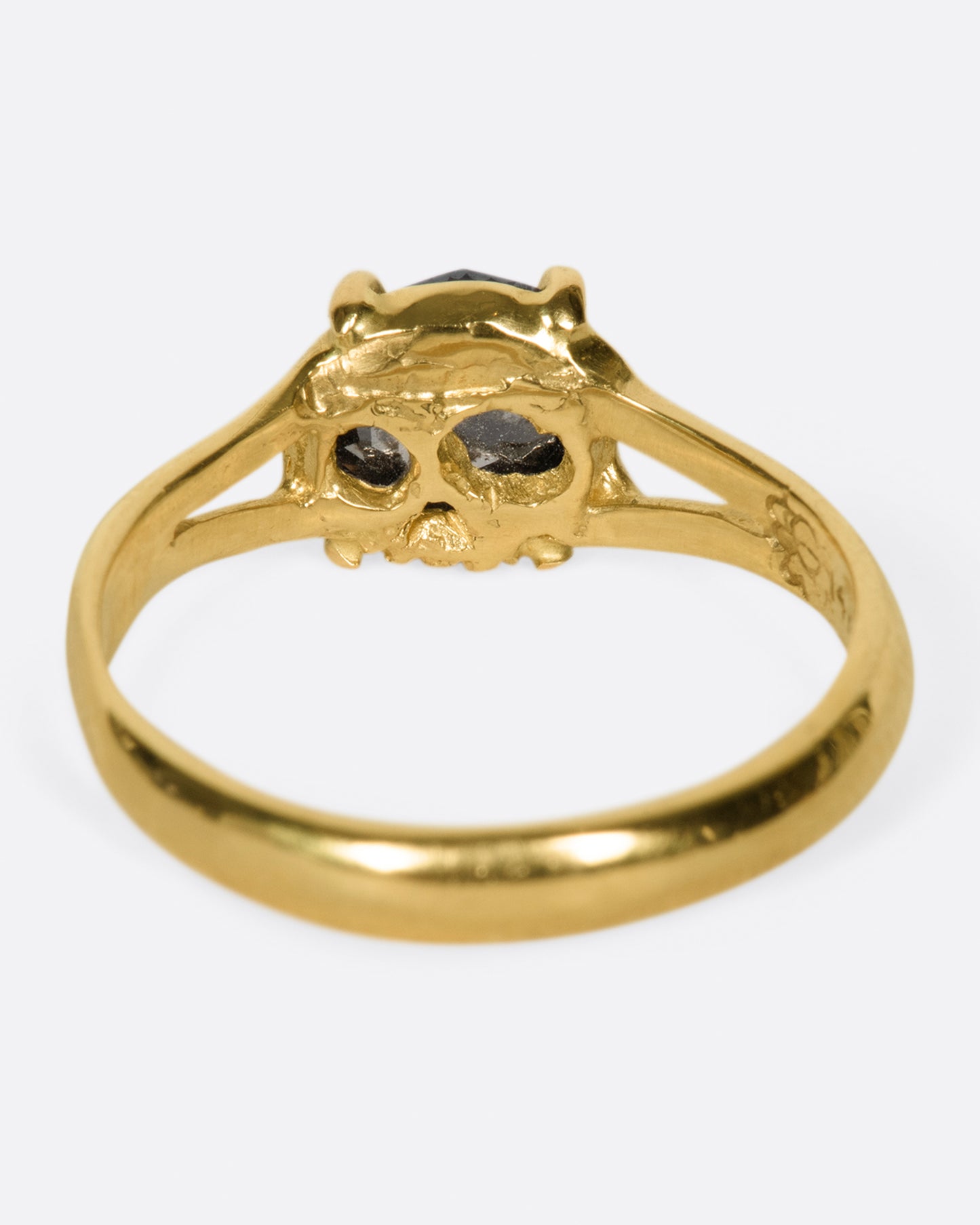 A split-shank gold ring with a prong set, rose cut, rustic diamond and "'till death" engraved on the inside.