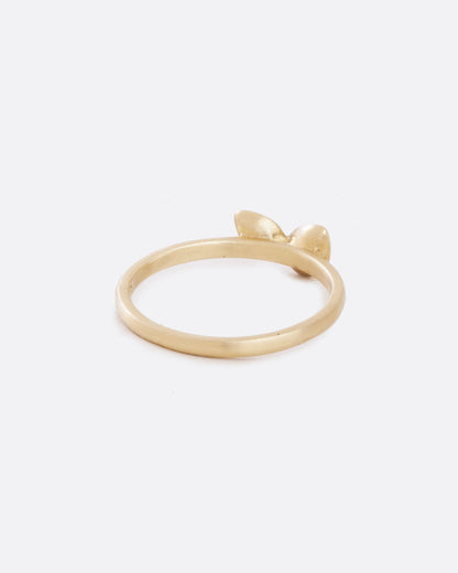 A yellow gold band with four asymmetrical diamonds stacked in a central geometric cluster. Shown from the back.