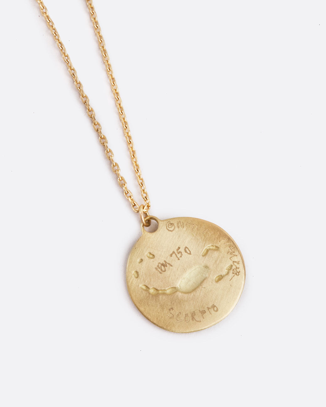 Close up back view of gold disc pendant on yellow gold chain