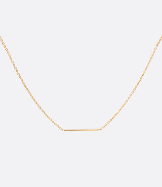 Close up birds eye view of three quarters of an inch gold bar set on yellow gold chain