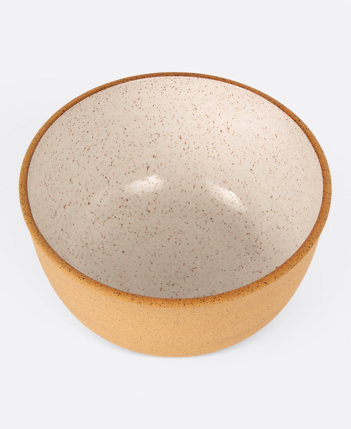 A stoneware salad bowl with a raw exterior and white glazed interior, shown from above.