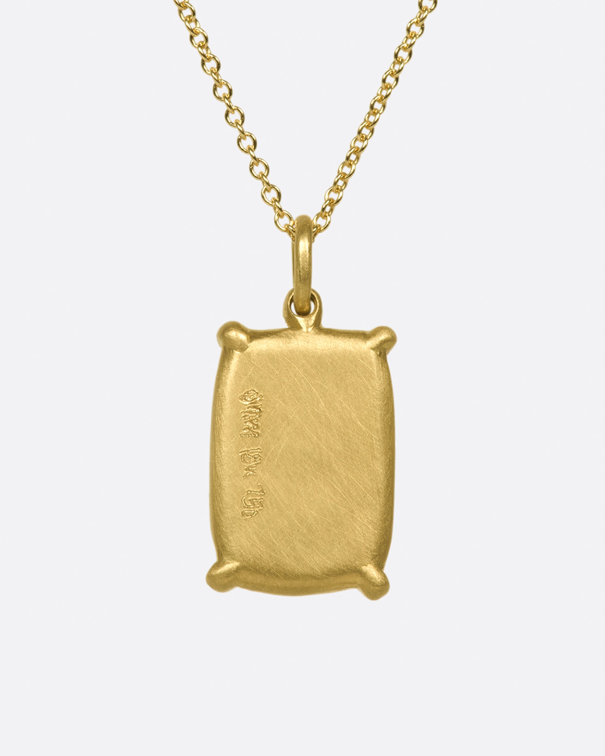 A large, rectangular tanzanite cabochon pendant set in matte gold prongs on a cable chain necklace.