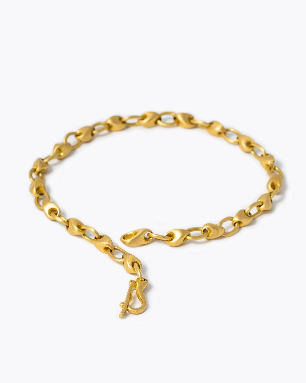 A 18k yellow gold handcrafted bracelet by Marian Maurer. The links alternate between ovals and pebble shapes, shown unclasped.