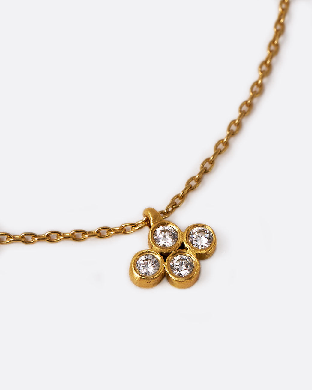 Marian Maurer yellow gold four diamond cluster necklace, shown laying flat.