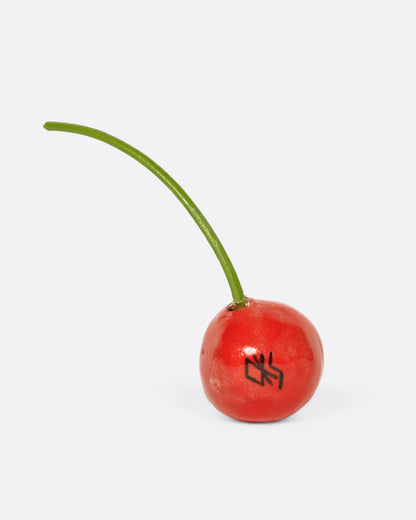 Porcelain red cherry sculpture, single cherry with a green stem showing the maker's mark