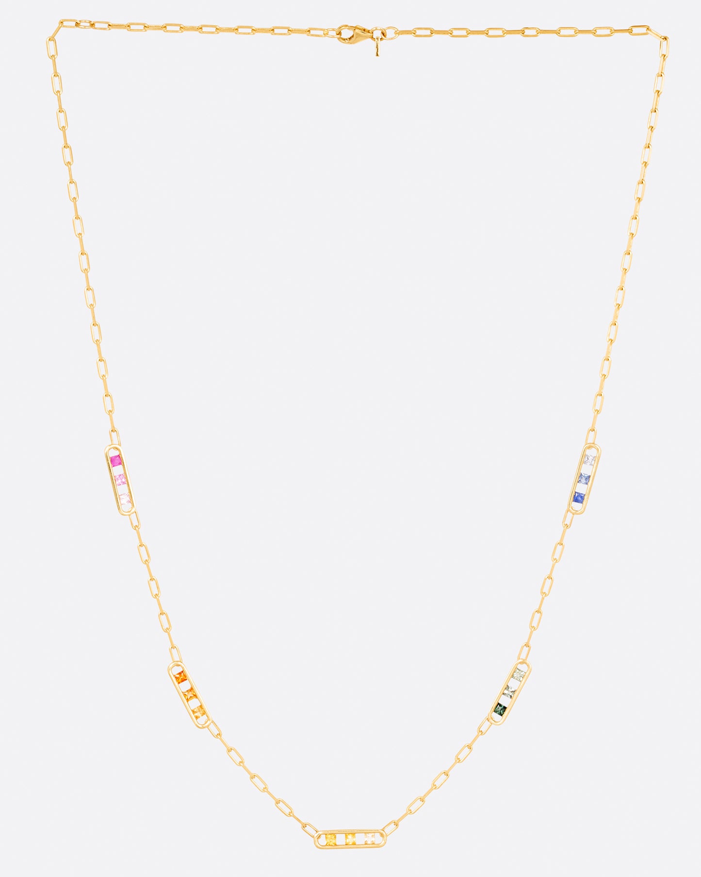 A yellow gold chain necklace with five stations containing princess cut rainbow sapphires, shown hanging.