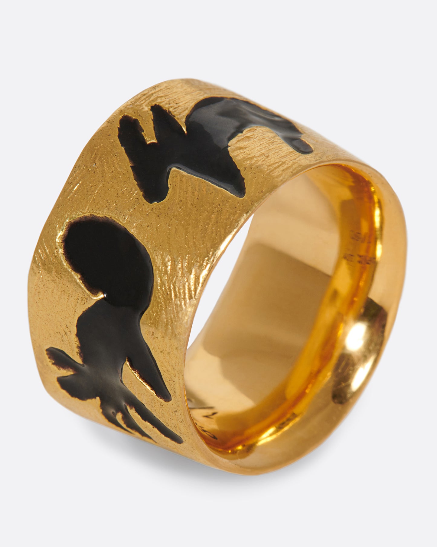 A high karat gold band with a range of different black enamel animal silhouettes.