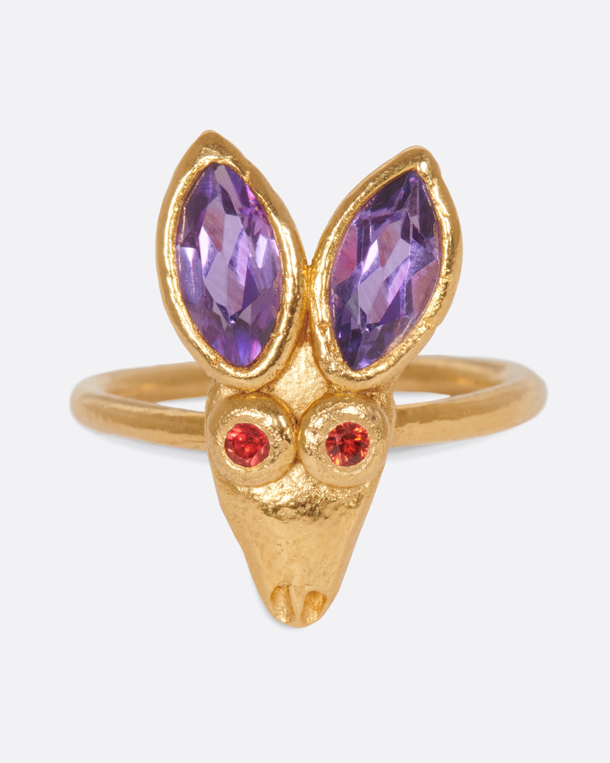A little, hand-formed rabbit ring with big amethyst ears and red sapphire eyes.