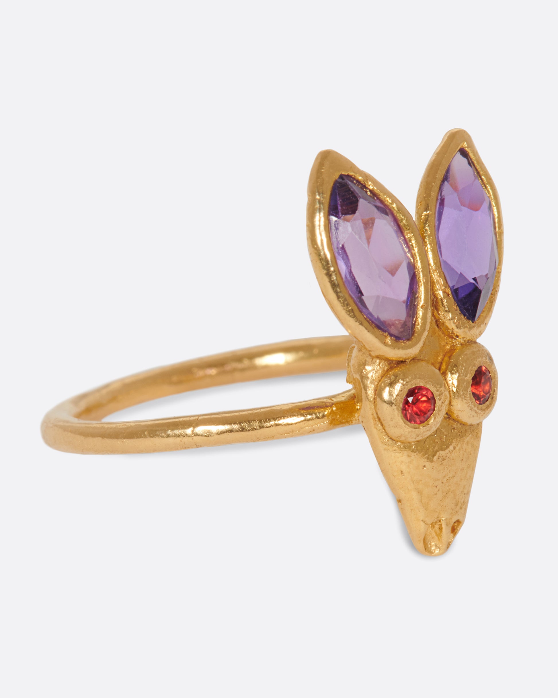 A little, hand-formed rabbit ring with big amethyst ears and red sapphire eyes.