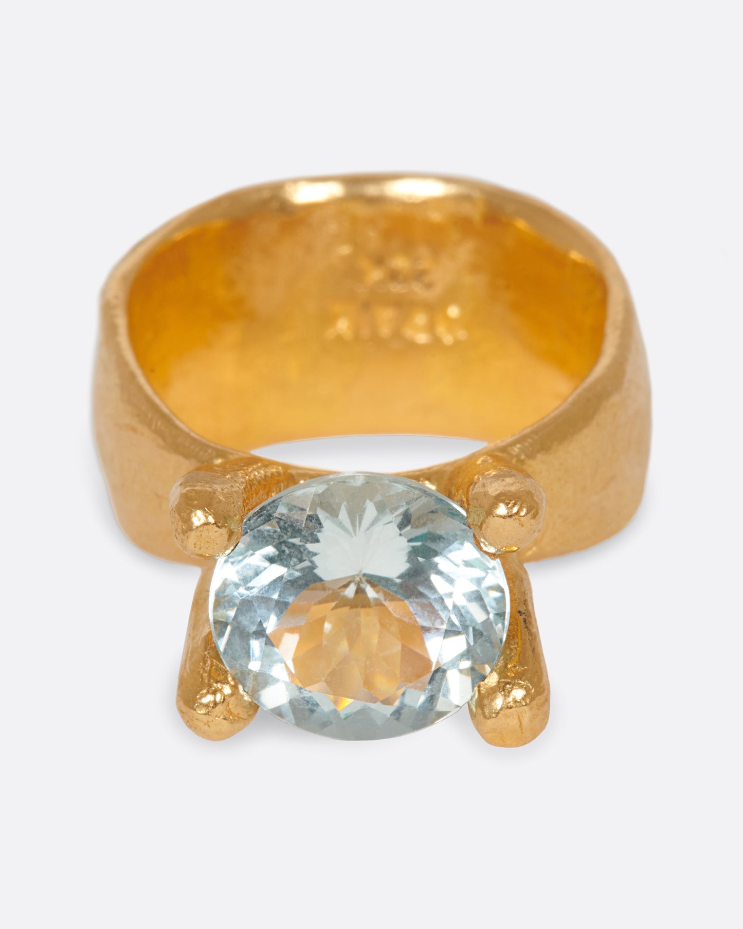 Hand-formed, high karat gold prongs contain a glorious aquamarine atop this ring.