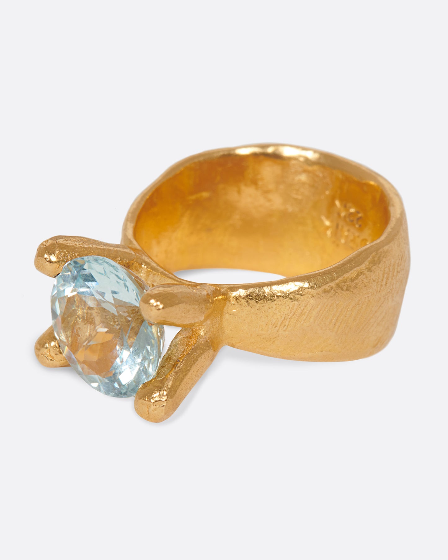 Hand-formed, high karat gold prongs contain a glorious aquamarine atop this ring.