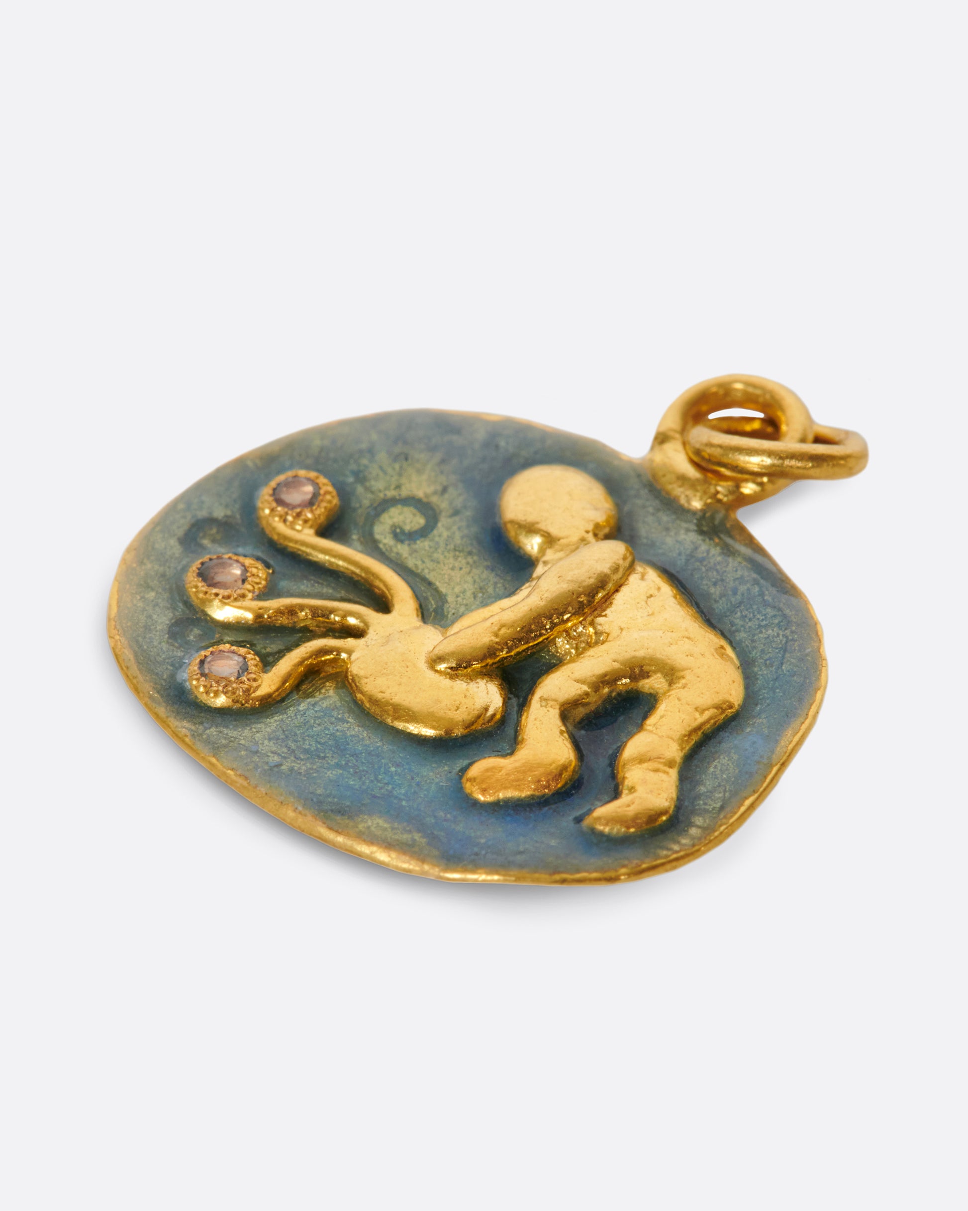 A hand formed medallion pendant with an Aquarius icon, pouring water dotted with aquamarines.