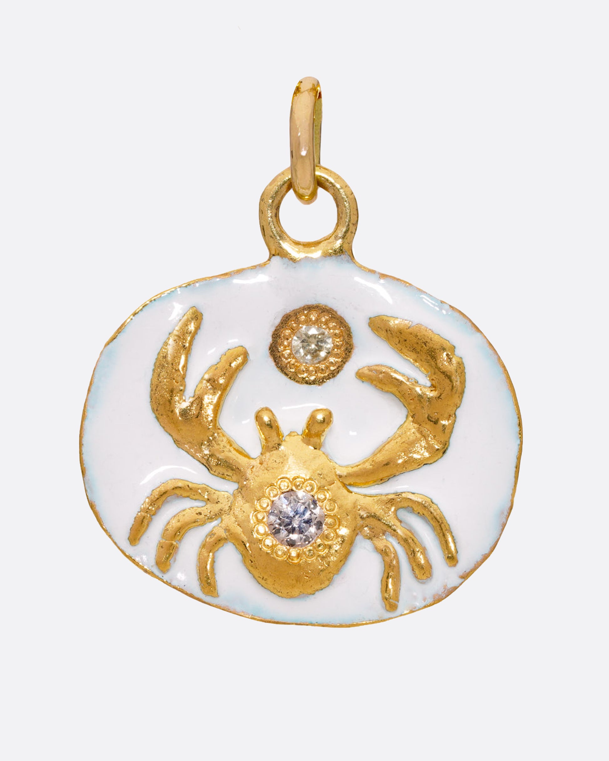 An oval gold pendant with a diamond accented Cancer crab.