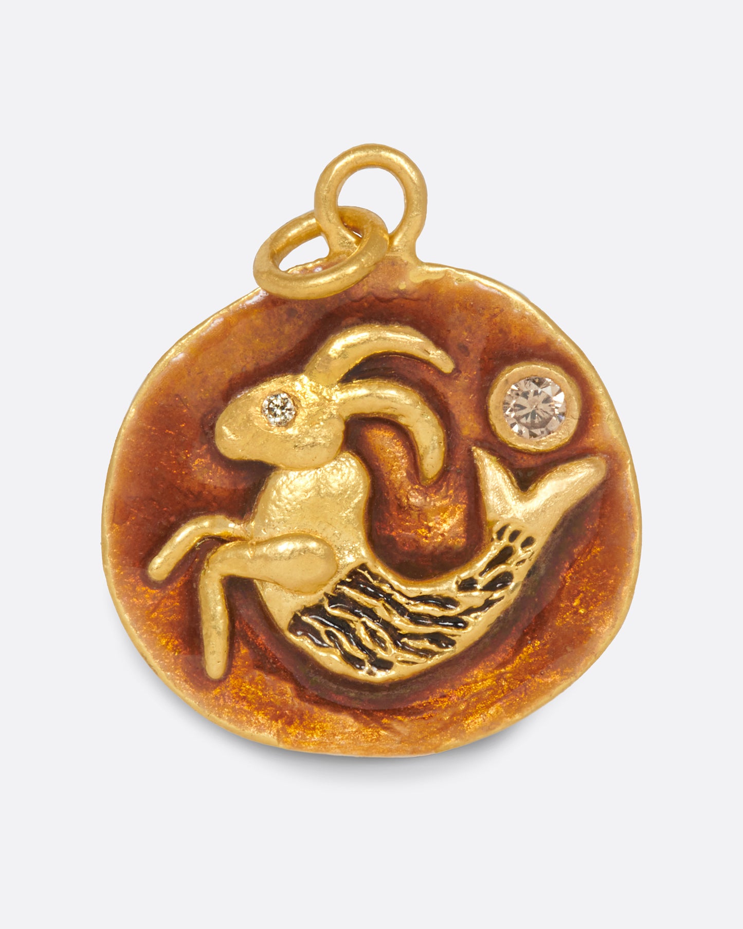 A round pendant featuring a hand-sculpted Capricorn with diamond accents.
