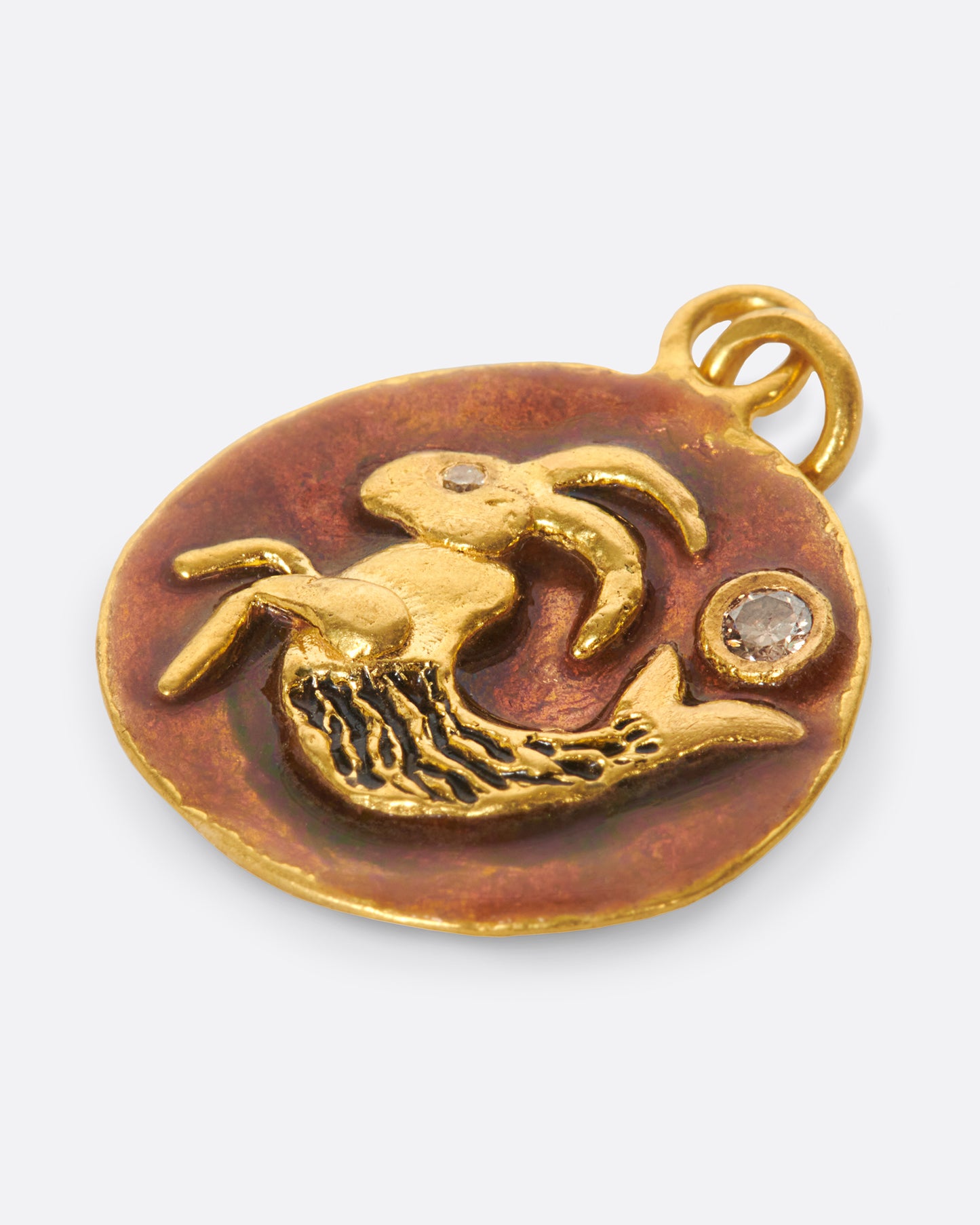 A round pendant featuring a hand-sculpted Capricorn with diamond accents.