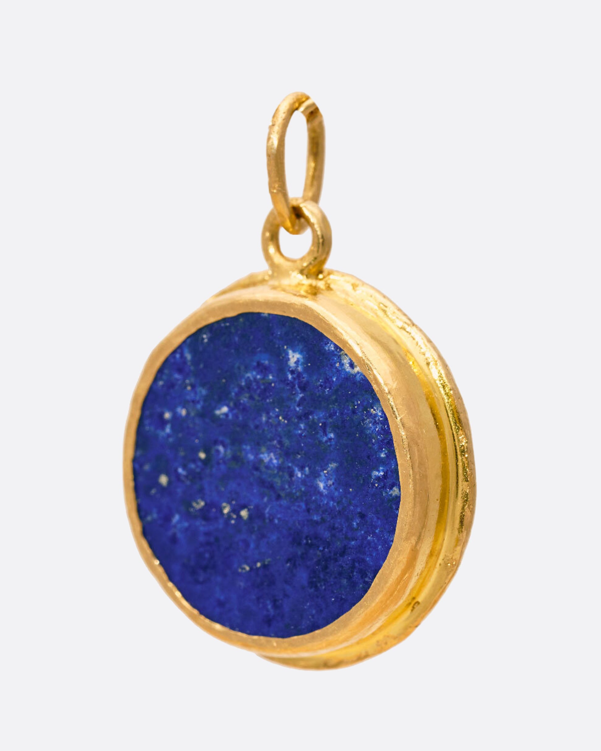 A round lapis Inner Eye pendant decorated with 22k gold and diamond details, shown from the back.