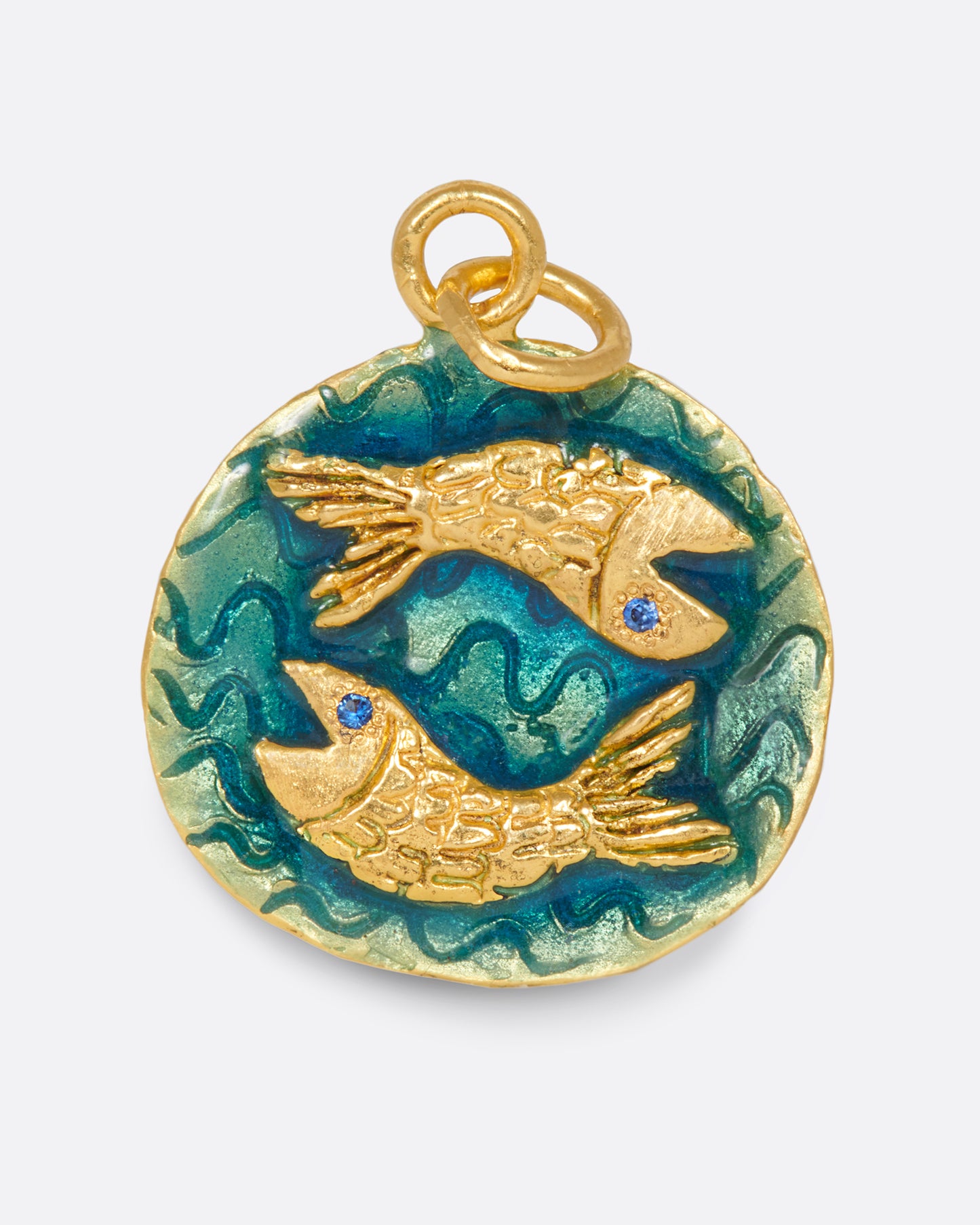 A round hand-sculpted pendant with the Pisces symbol, each fish with a blue sapphire eye.