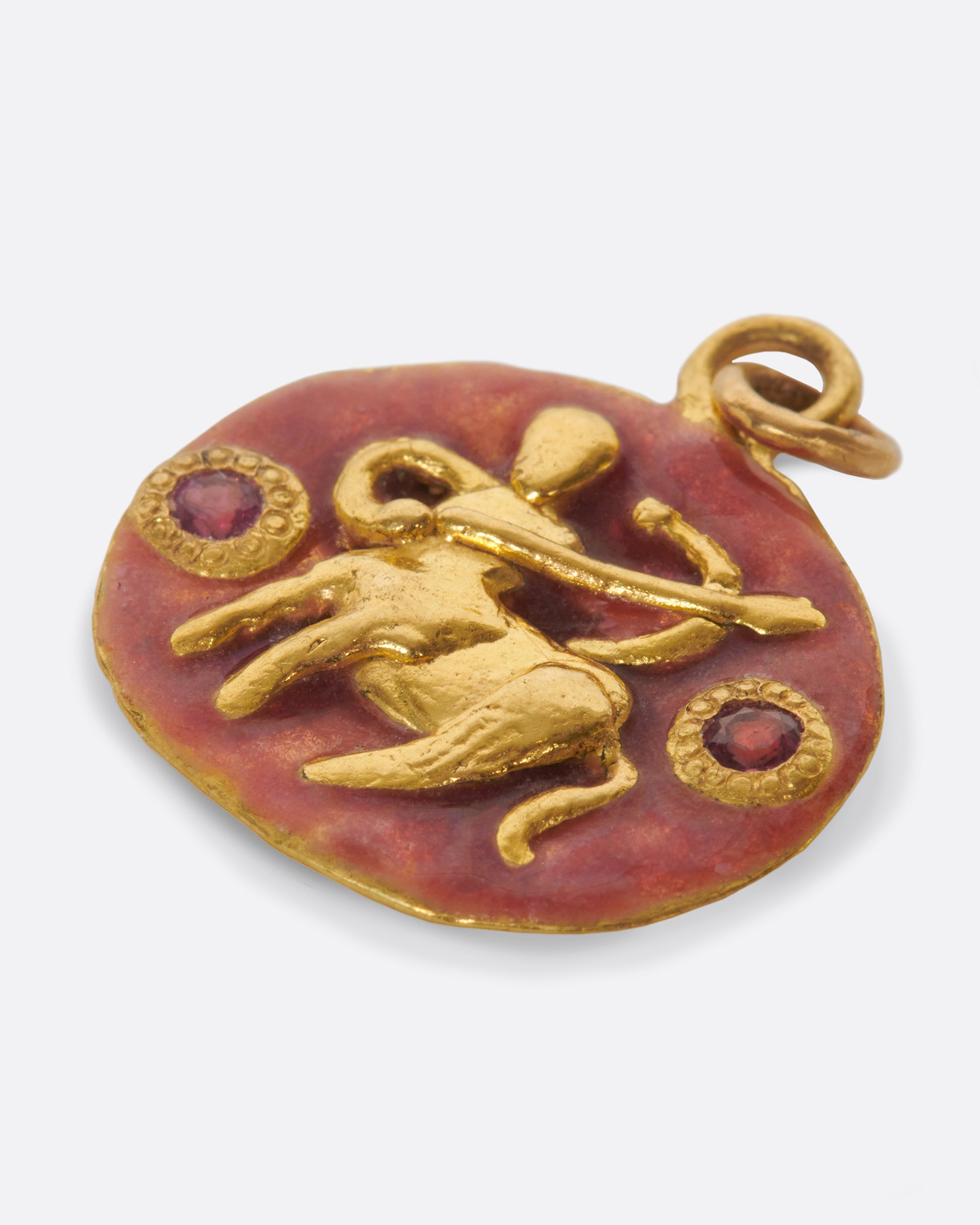 An oval gold pendant with rosy pink enamel and a hand-sculpted Sagittarius icon.
