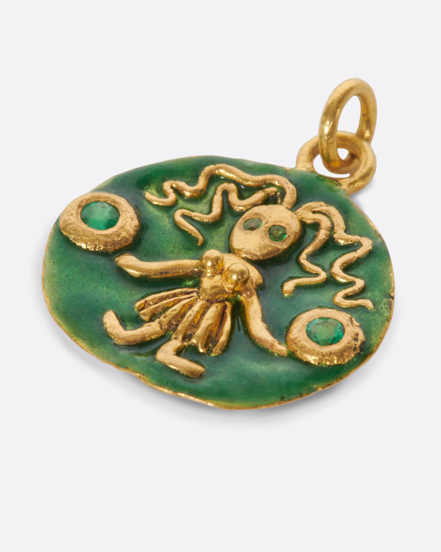 A round, high karat gold medallion pendant featuring a Virgo icon holding two tsavorite garnets.