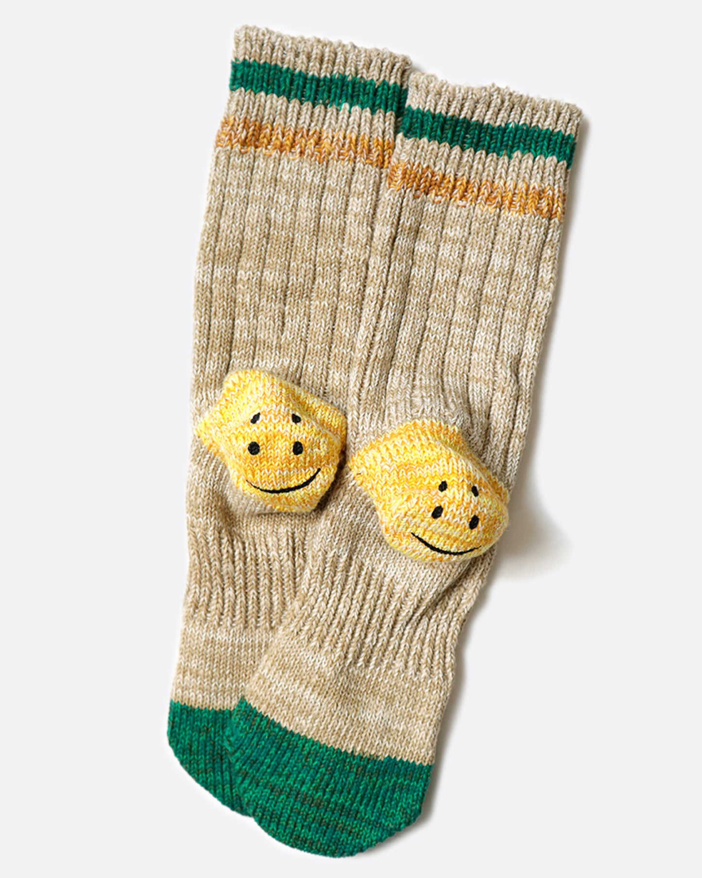 A pair of beige ribbed tube socks with green toe caps and yellow smiley heels, shown laying flat.