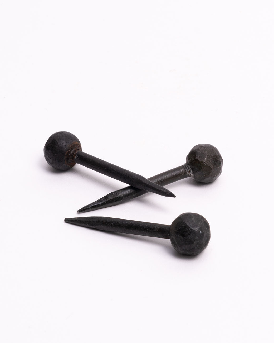 A group of three round head iron nails.