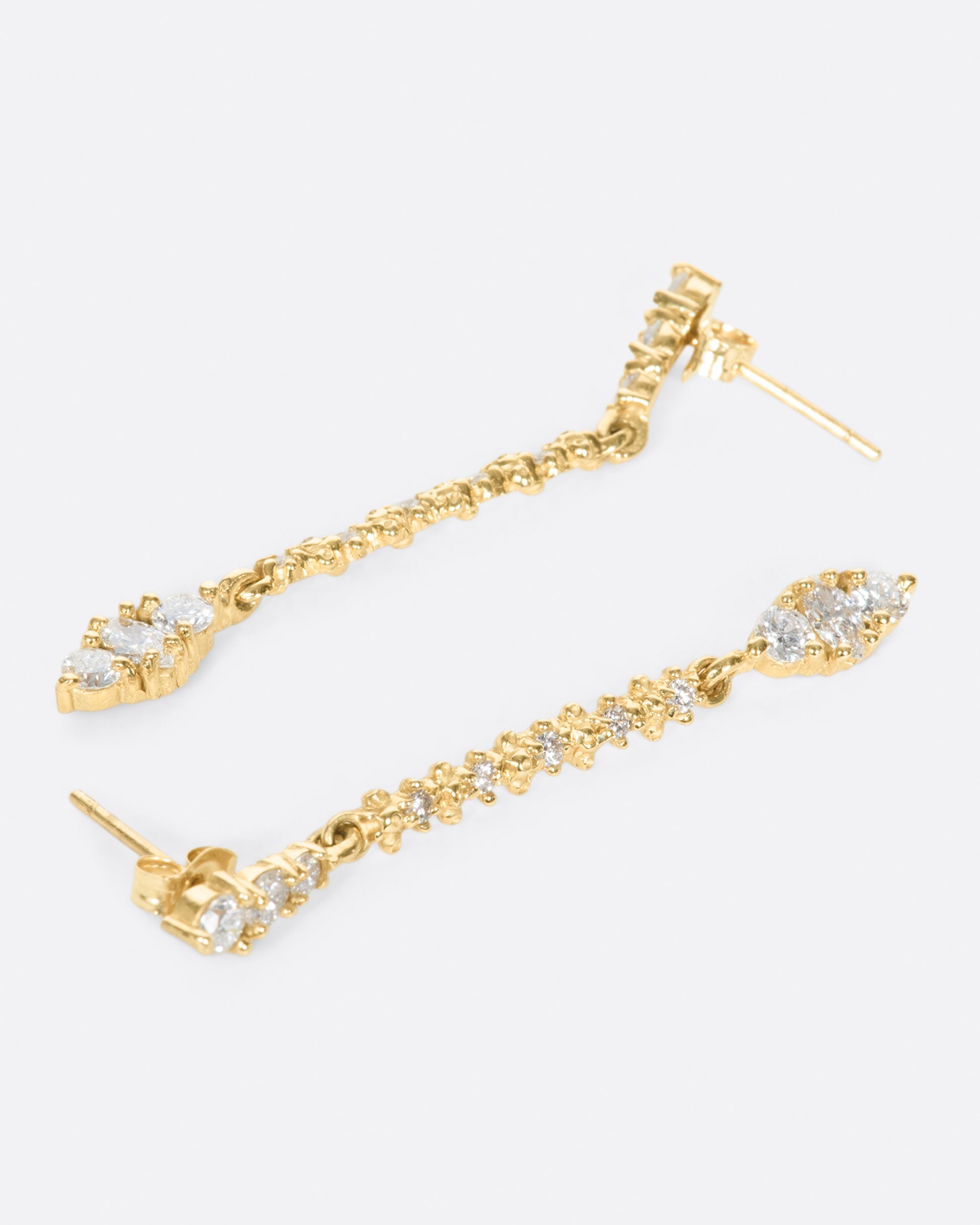 A pair of classic stud earrings with textured diamond drops.