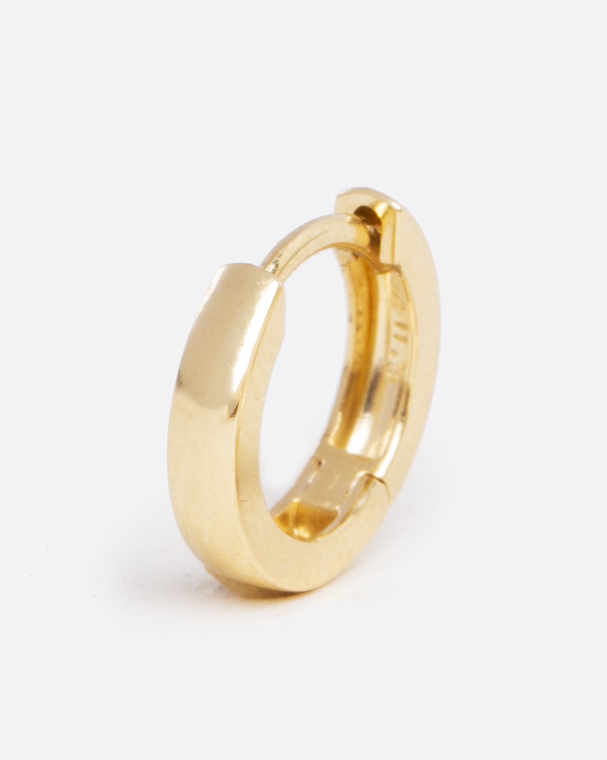 a tiny yellow gold hoop earring with a hinge in the middle