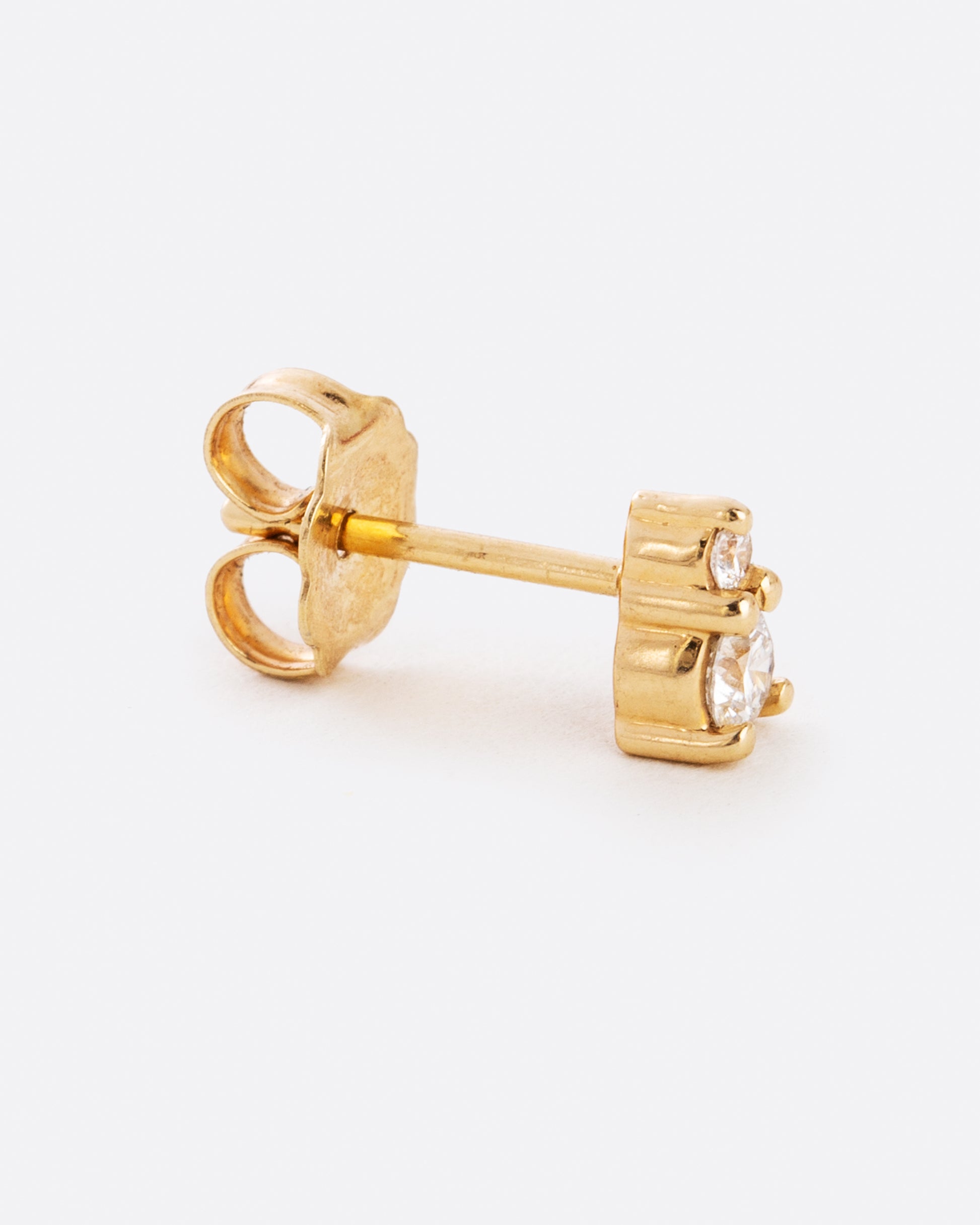 yellow gold earring with two diamonds stacked from a side angle