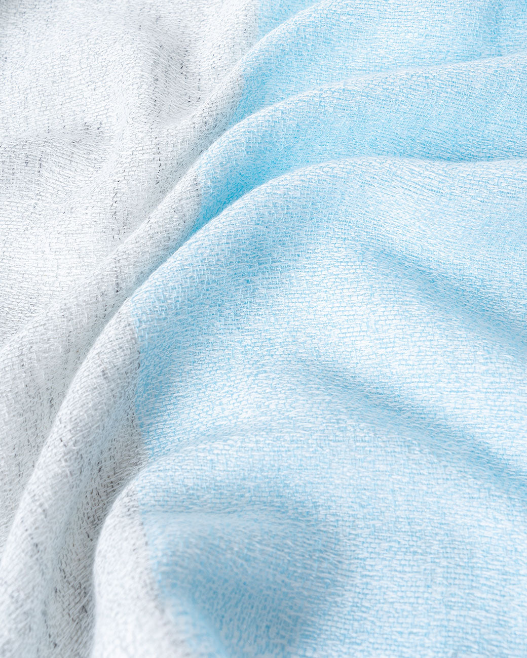 Close up of Japanese Shukin gauze hand towel, half blue and half gray.