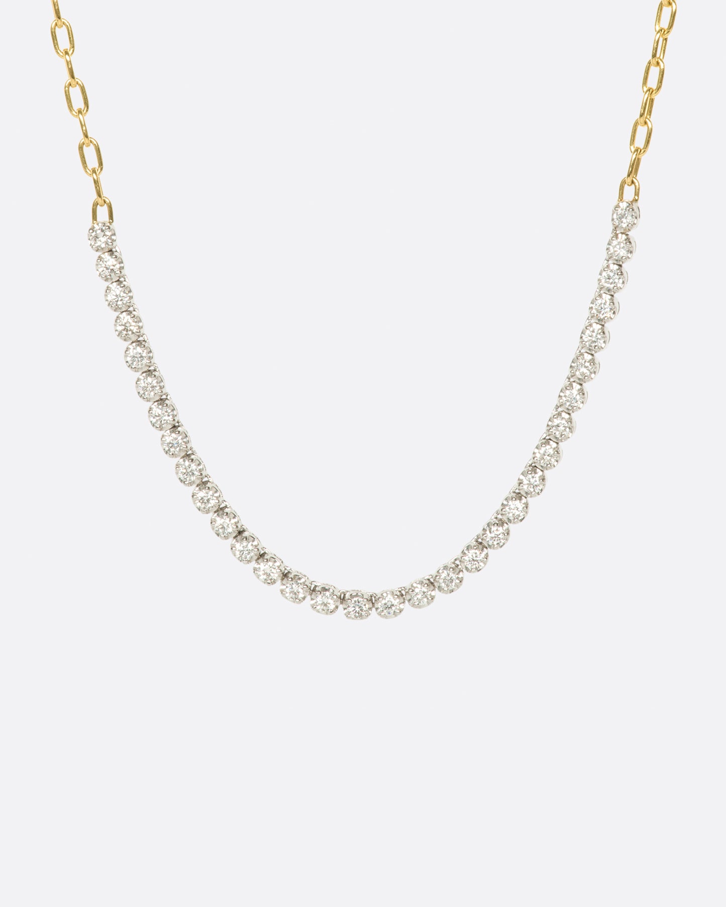 A yellow gold, oval link, chain necklace with four inches of contrasting white diamonds.