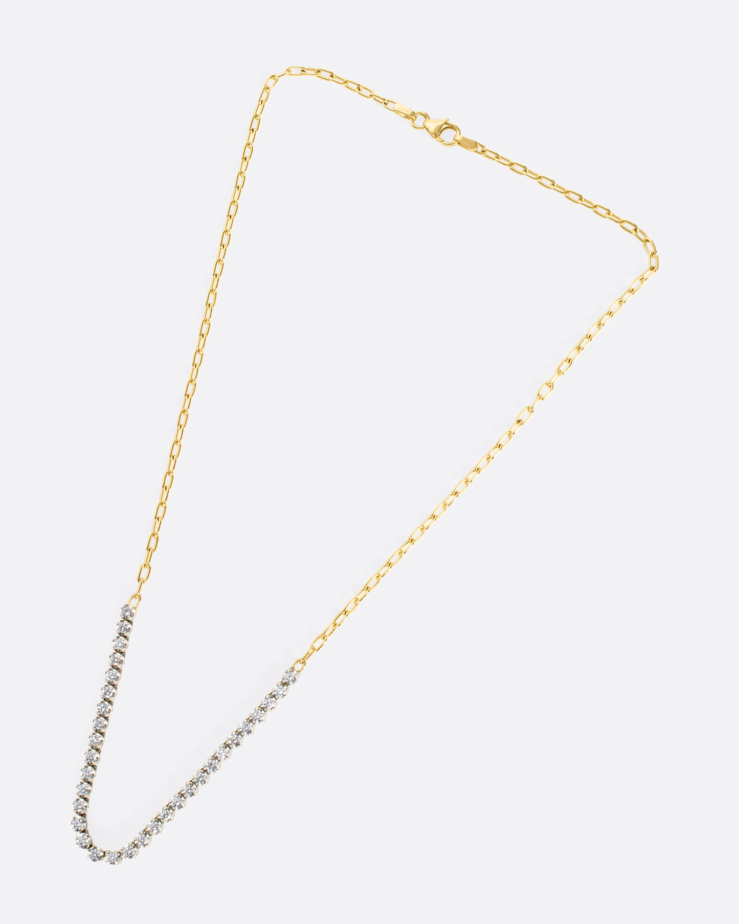 A yellow gold, oval link, chain necklace with four inches of contrasting white diamonds.