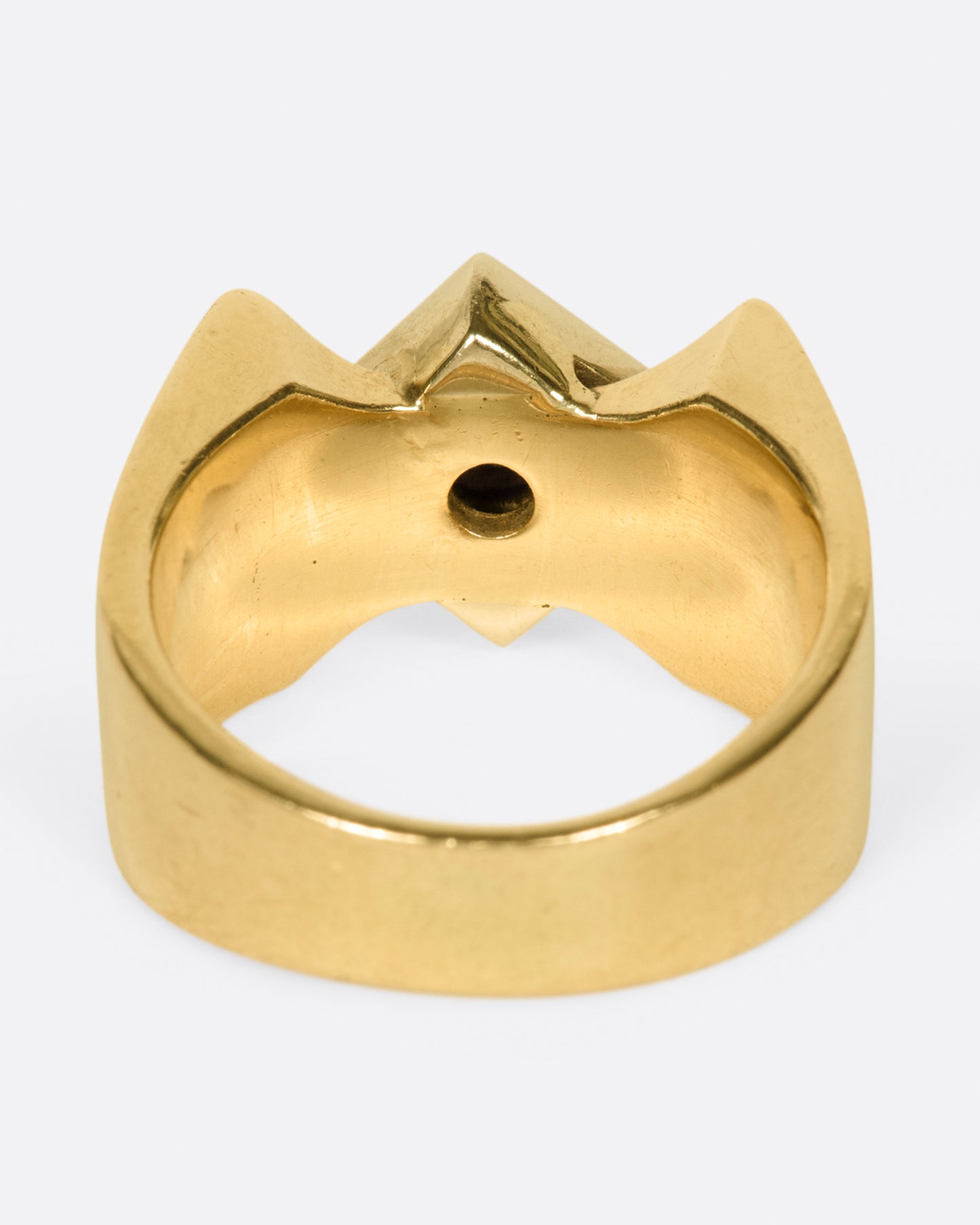 A heavy, gold, X-shaped ring with a white gold square and a round diamond at its center.