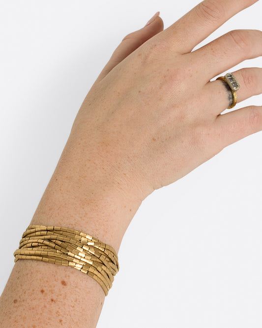 A heavy, segmented, nearly liquid gold bracelet.