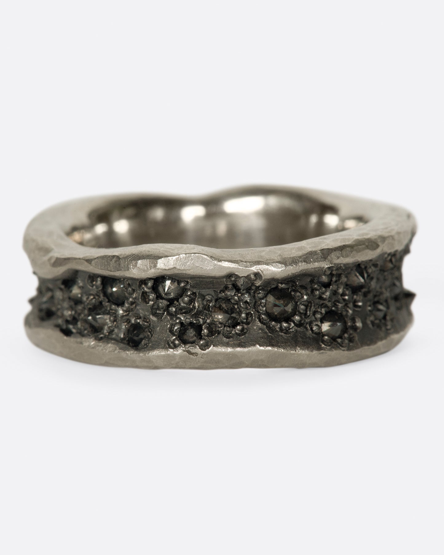 A concave, hammered palladium band with inverted black diamonds throughout its center.