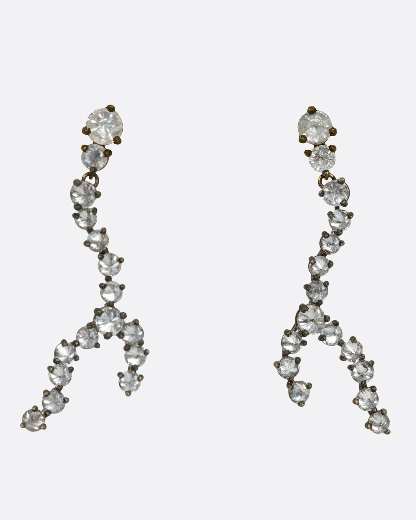 A pair of organically shaped earrings made from inverted diamonds set in darkened white gold settings.