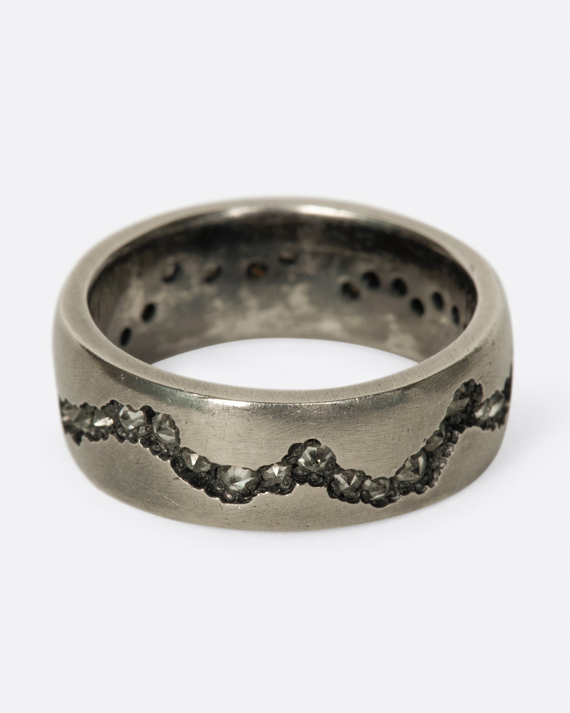 A wide palladium band with inverted diamonds set in a hand cut fissure through the center of the ring.