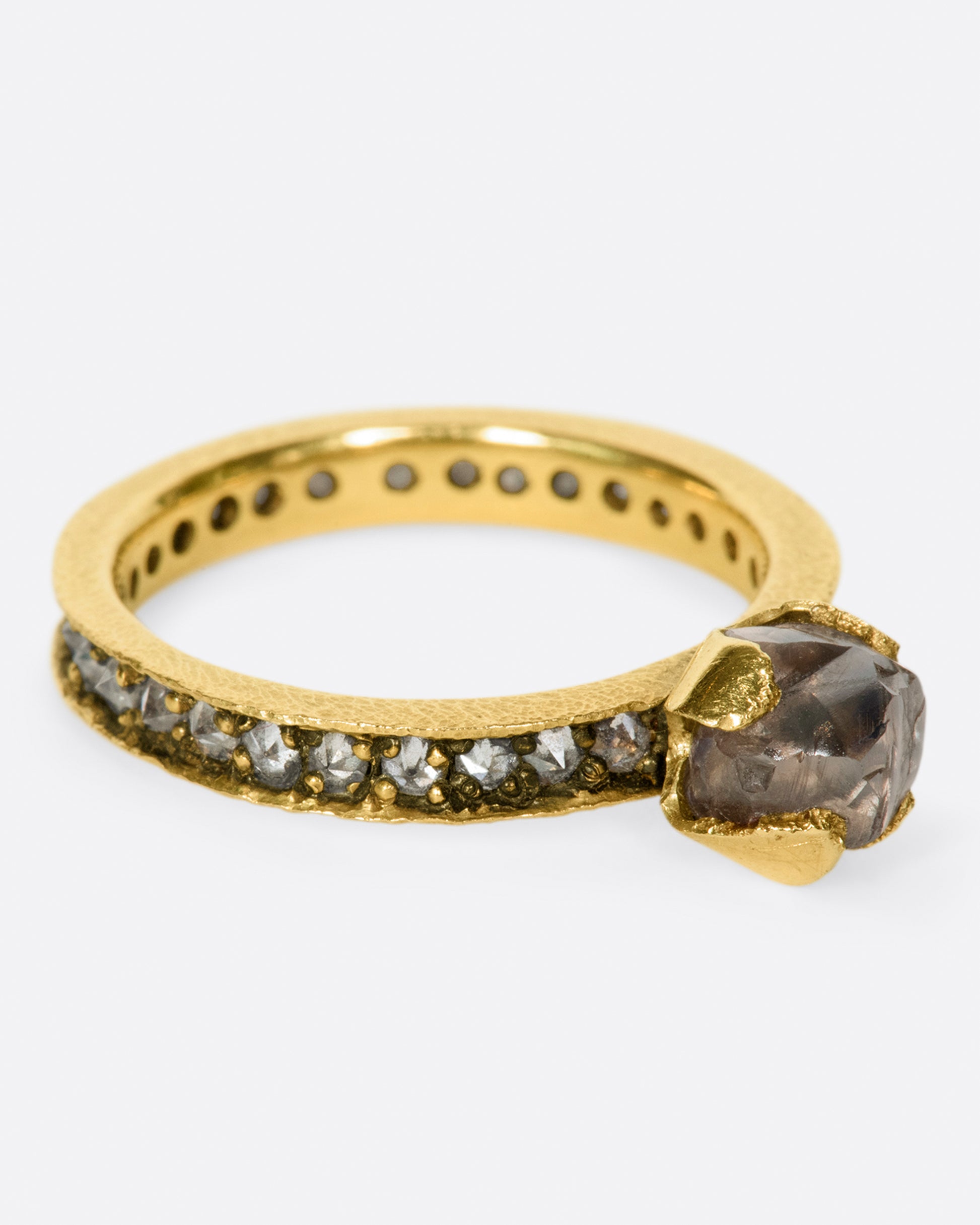 A yellow eternity band with inverted diamonds, crowned by a prong set raw yellow diamond.