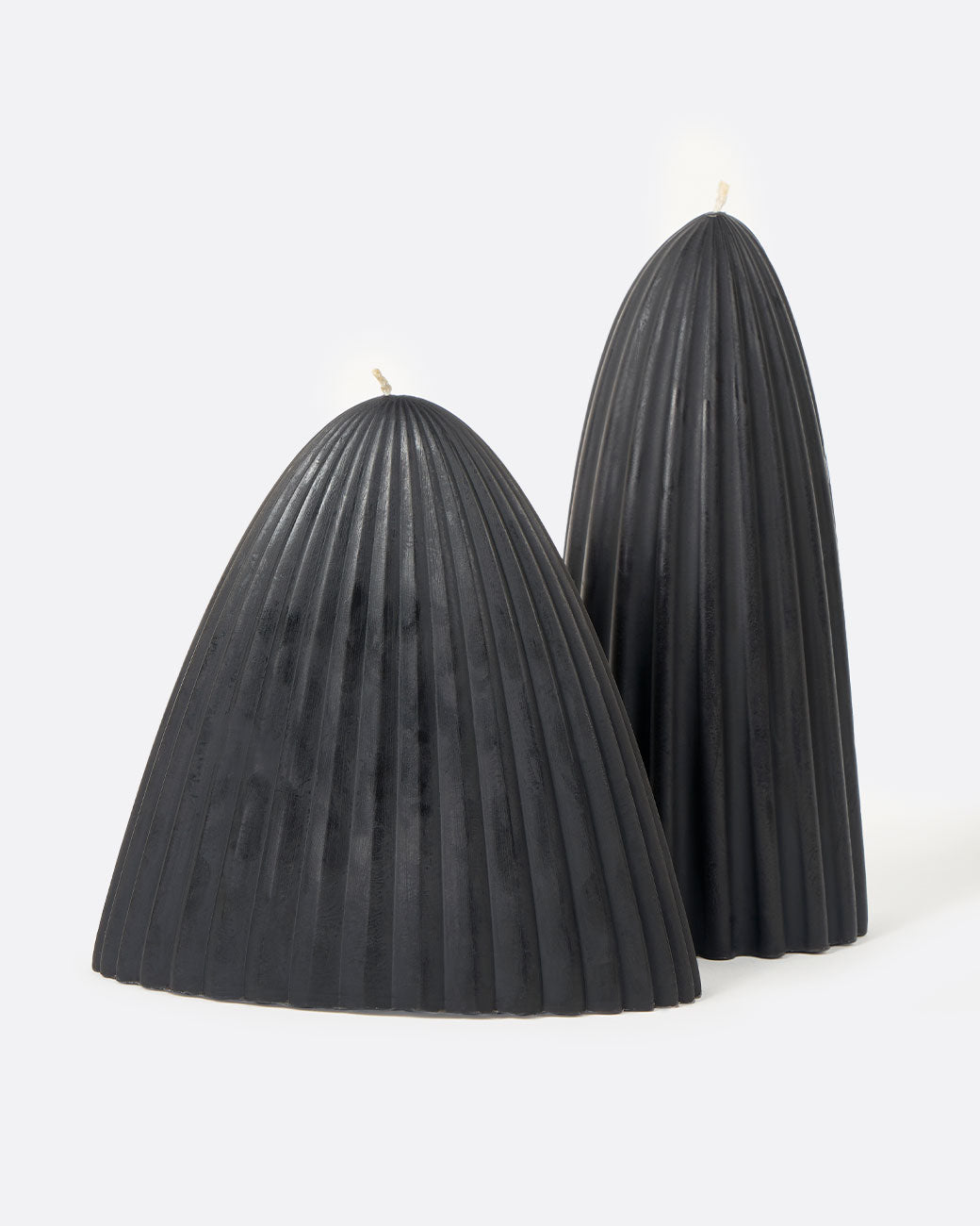 Two black natural beeswax tusk candles, one short and wide and the other narrow and tall.